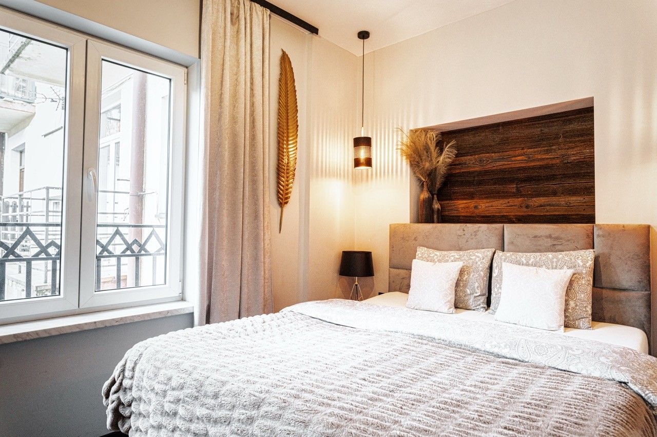 Sypialnia apartamentu Halny z oknem wychodzącym na Zakopane