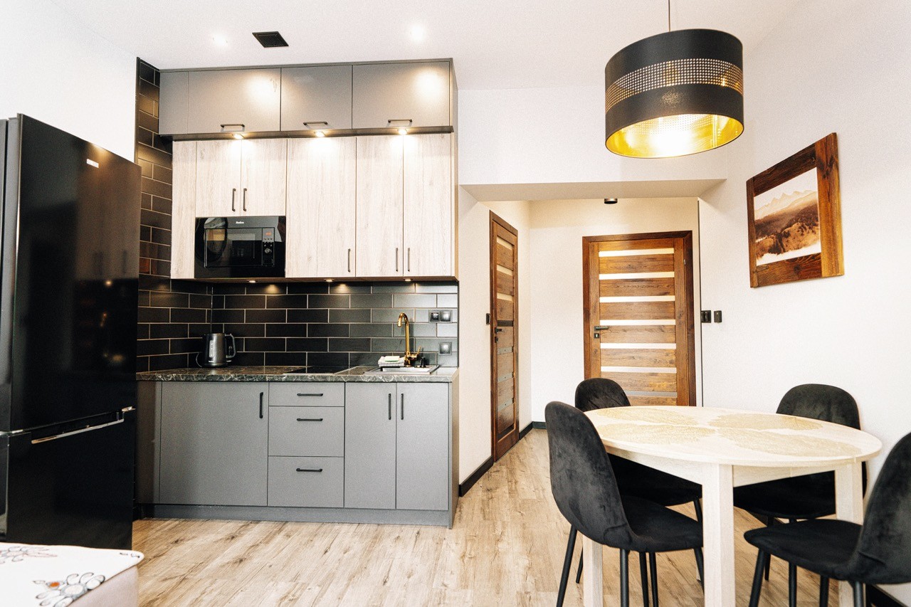 Kuchnia w apartamencie Halny w Zakopanem — pełna zabudowa z mikrofalą i jadalnia