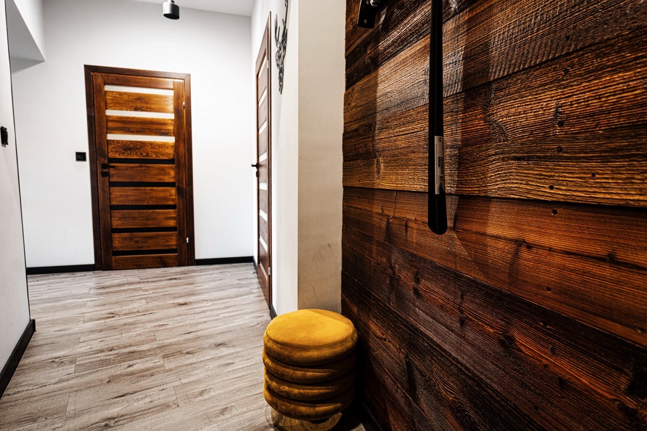 Korytarz apartamentu Halny w Zakopanem ze ścianą ze starego drewna
