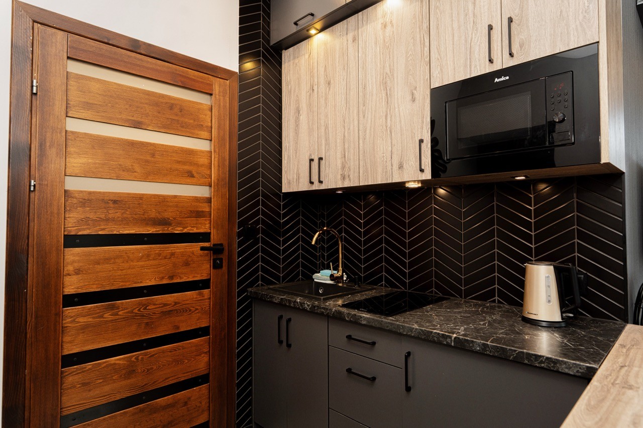 Aneks kuchenny apartamentu Rysy z szafkami i czarną armaturą