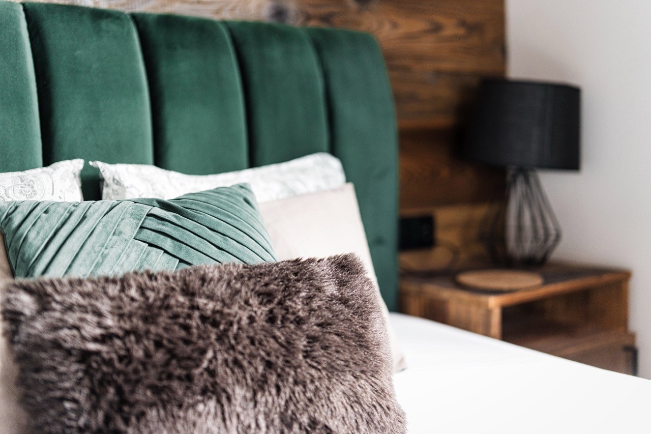Zbliżenie zielonego zagłówka i poduszek w apartamencie Rysy