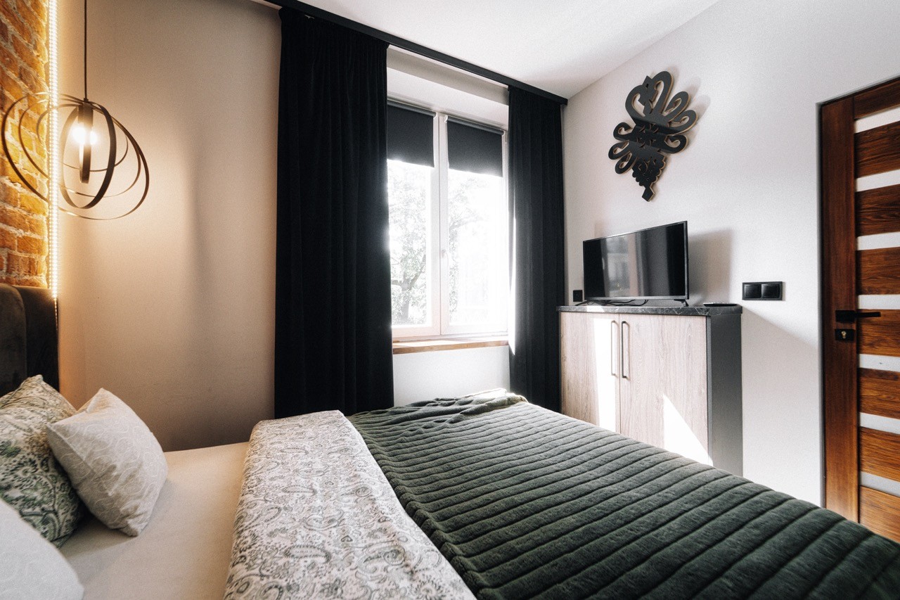 Druga sypialnia z łóżkiem dwuosobowym i telewizorem w apartamencie Watra