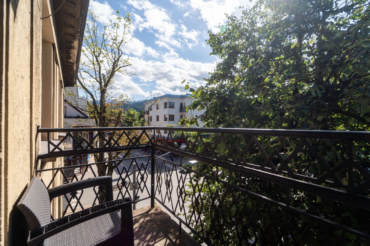 Balkon apartamentu Watra otoczony zielenią w centrum Zakopanego